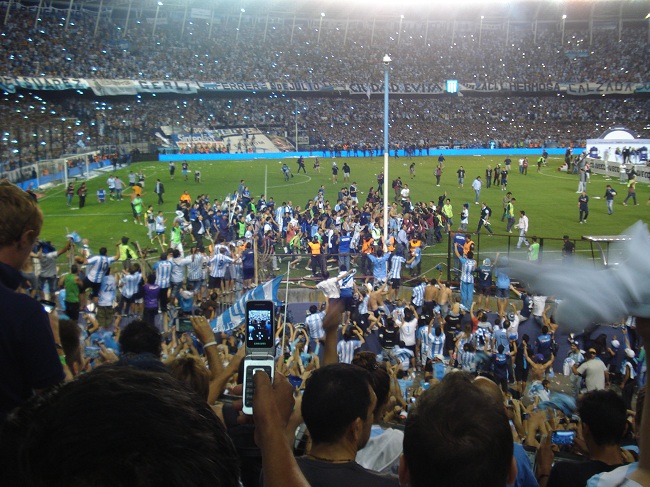 Volta olímpica: hinchas se penduram nas grades e sobem nas muretas para festejar Milito