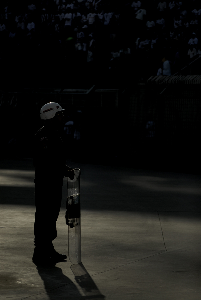 PM equipado com escudo observa os torcedores desde a pista que cerca o gramado do Pacaembu PM equipado com escudo observa os torcedores desde a pista que cerca o gramado do Pacaembu