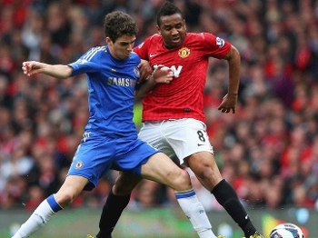 Brasileiros Oscar e Anderson disputam bola durante Manchester United x Chelsea