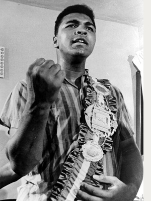 Cassius Clay posa para fotos com o cinturão dos pesados após derrotar Liston Cassius Clay posa para fotos com o cinturão dos pesados após derrotar Liston