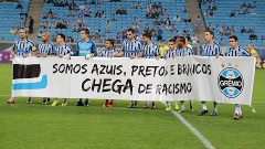 Jogadores do Grêmio entram em campo com faixa contra o racismo antes da partida contra o Bahia