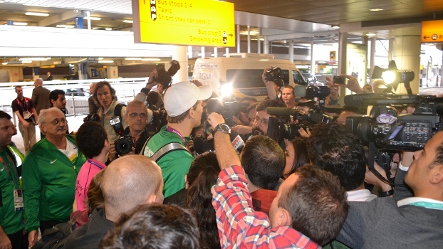 O nadador Cesar Cielo foi cercado por jornalistas no aeroporto de Heathrow