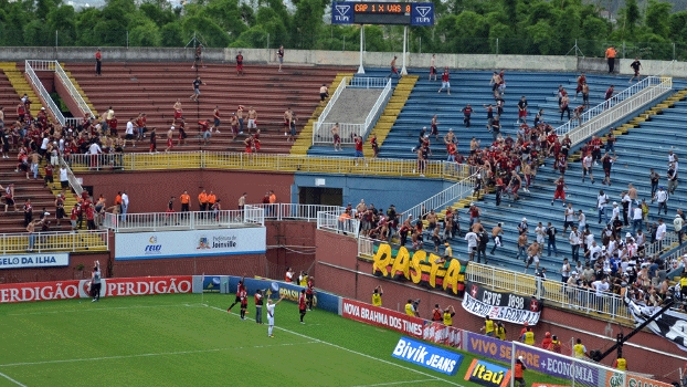 Jogadores de Atlético-PR e Vasco tentam conter, do gramado, a briga entre os torcedores das equipes